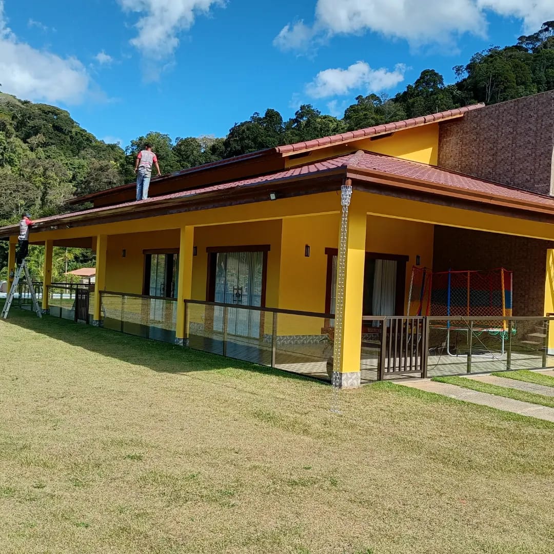 Calha instalada em telhado de casa com corrente de chuva