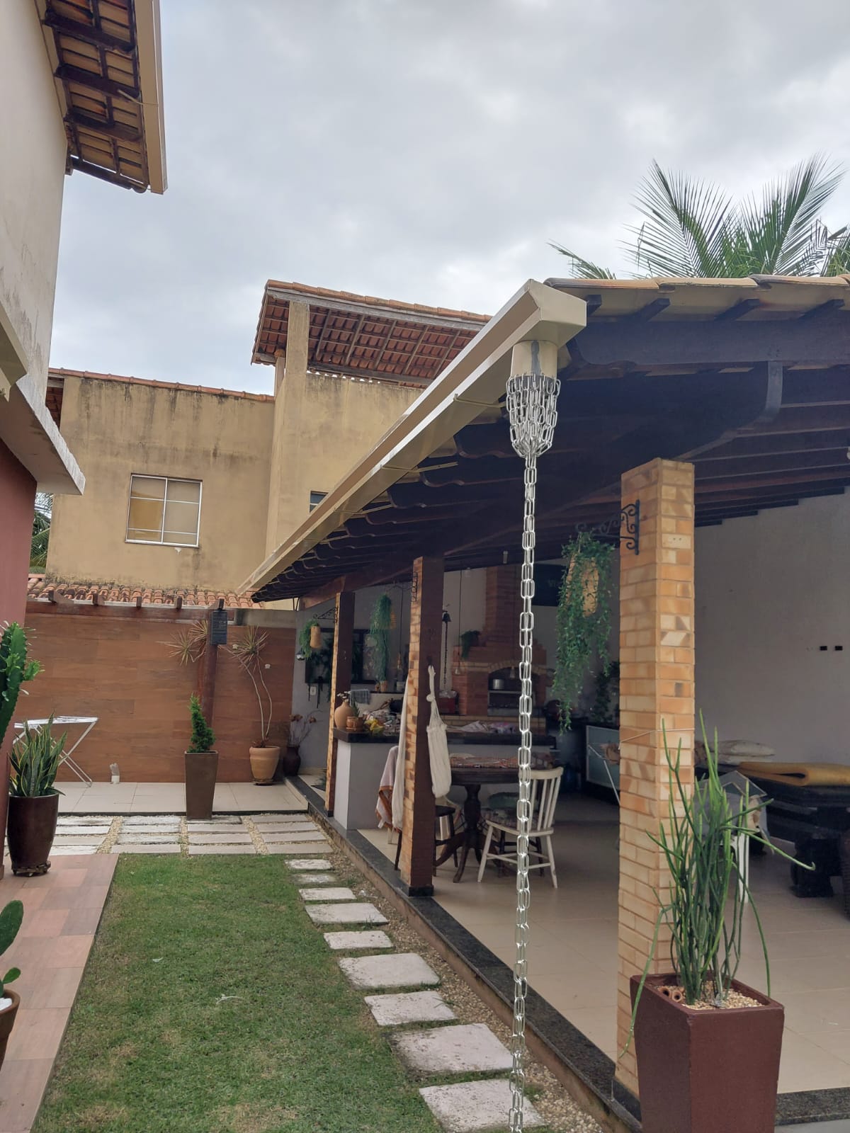 Calha instalada em estrutura de madeira com corrente de chuva em área gourmet