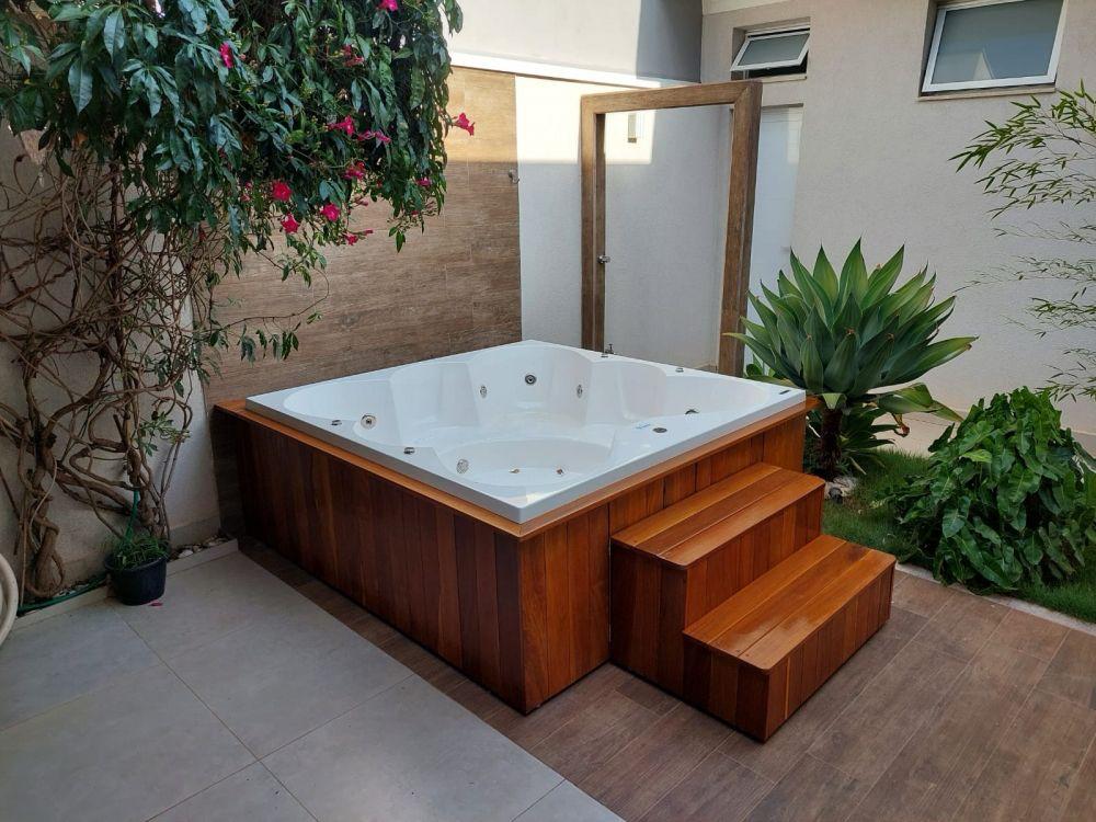 Deck de madeira com escada para hidromassagem no jardim