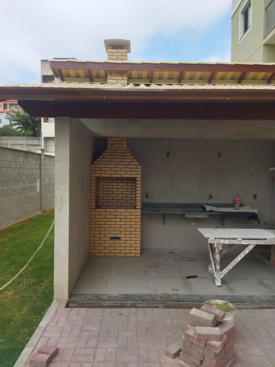 Churrasqueira de alvenaria em execução sob cobertura de telhado